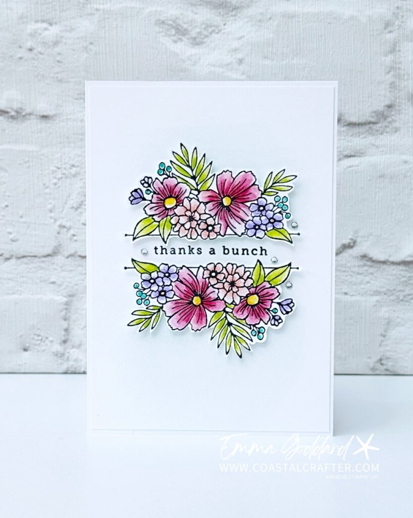 A simple white card with a focal image of flowers in the middle. These have been coloured with watercolour pencils and a wink of stella pen for some added sparkle