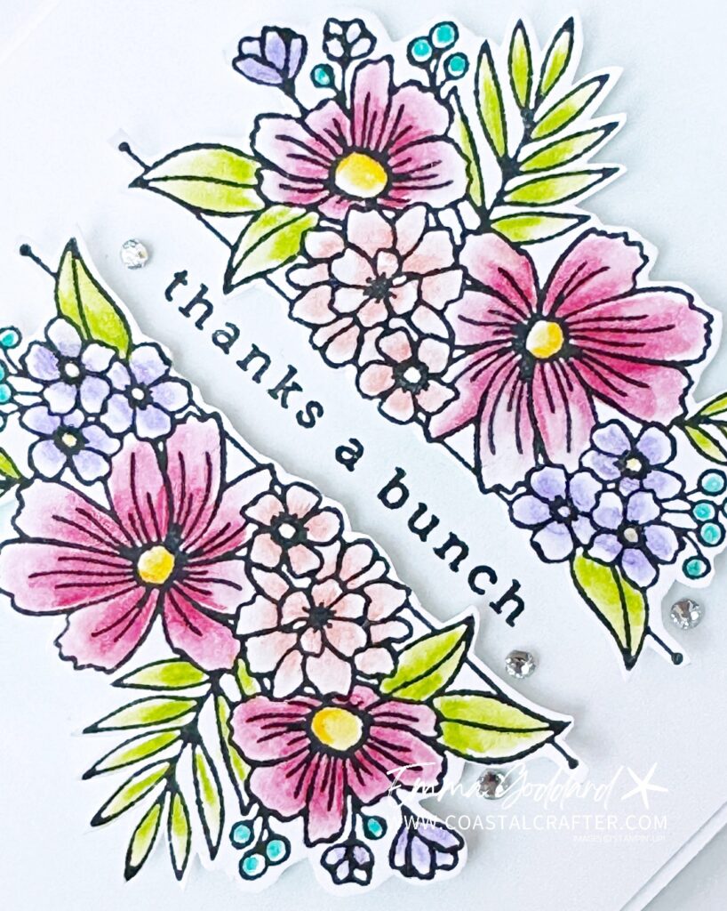 A simple white card with a focal image of flowers in the middle. These have been coloured with watercolour pencils and a wink of stella pen for some added sparkle