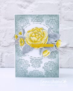Handmade card featuring a large Daffodil Delight rose with Smoky Slate leaves coloured with Stampin' Blends, made using the Sweetly Sentimental and Echoes of Details focus products. The rose sits on a white stitched circle die cut over a Smoky Slate damask patterned background, with Grey Granite linen ribbon and a Crushed Curry sentiment strip reading 'have a lovely day', hot foiled."